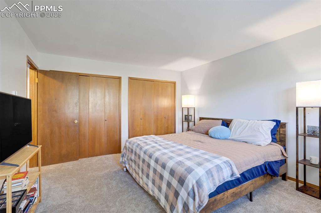 2387 Stepping Stones Way Colorado Springs, CO 80904 - Photo 18 of 35 a bedroom with a bed and a flat screen tv