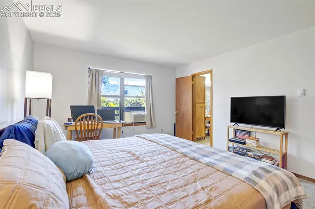 a bedroom with bed tv and window