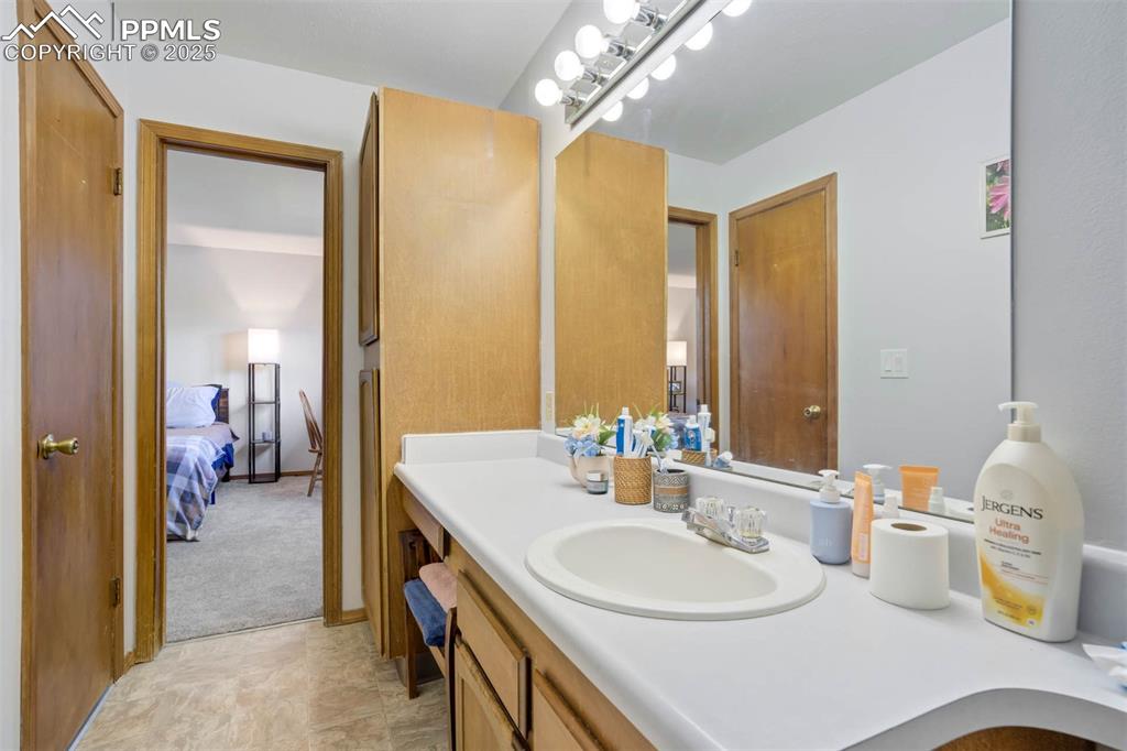 2387 Stepping Stones Way Colorado Springs, CO 80904 - Photo 21 of 35 a en suite bathroom with a double vanity sink and a mirror