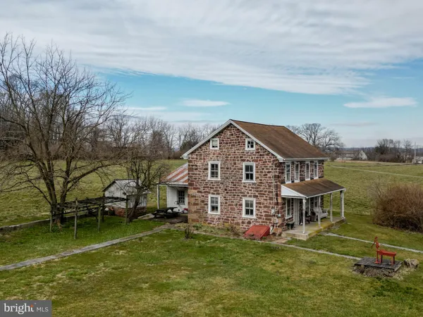 a aerial view of a house next to a big yard with plants and large trees