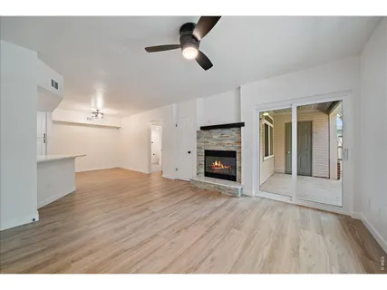 a view of empty room with wooden floor and fireplace