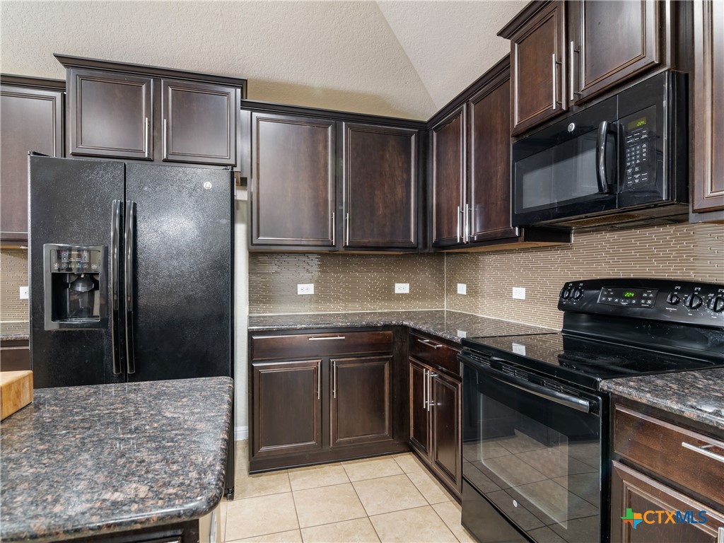 2231 Westover Loop New Braunfels, TX 78130 - Photo 14 of 36 a kitchen with granite countertop a sink stove and refrigerator