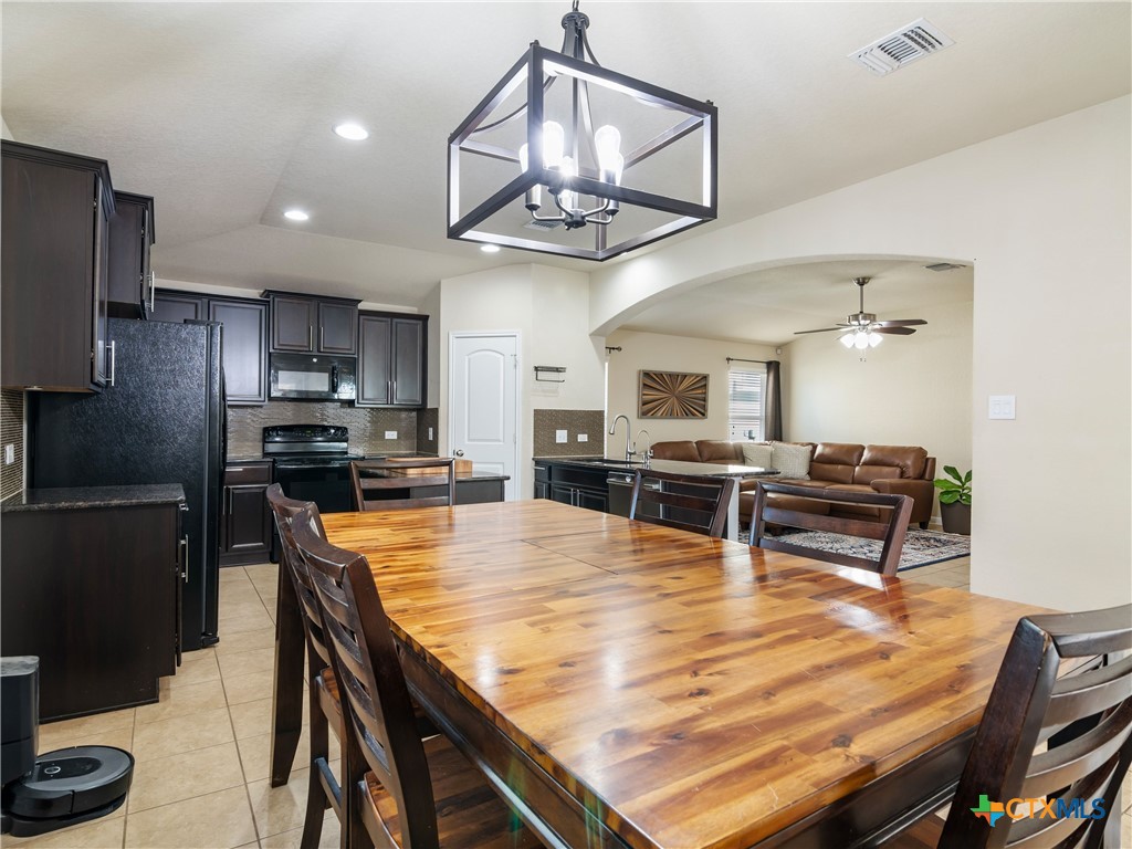 2231 Westover Loop New Braunfels, TX 78130 - Photo 18 of 35 a dining room with wooden floor a chandelier a wooden table and chairs