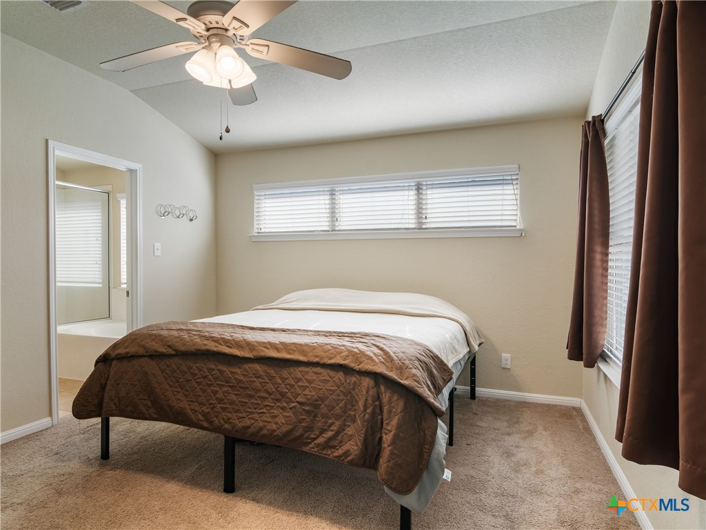 2231 Westover Loop New Braunfels, TX 78130 - Photo 20 of 35 a bedroom with a bed and a chandelier
