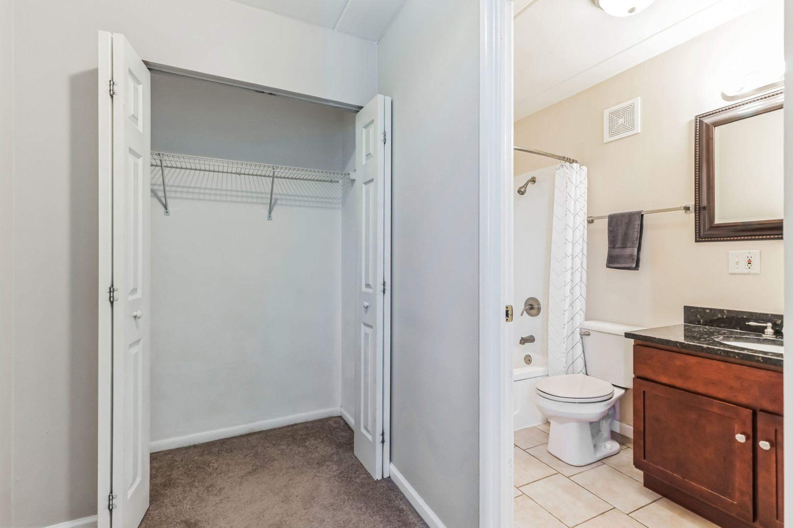 225 South Rohlwing Road, Unit 218 Palatine, IL 60074 - Photo 9 of 20 a bathroom with a toilet sink a mirror and shower