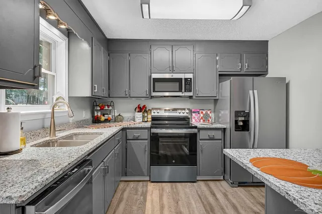 a kitchen with granite countertop stainless steel appliances and wooden cabinets