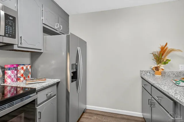 a kitchen with stainless steel appliances granite countertop a refrigerator and a stove