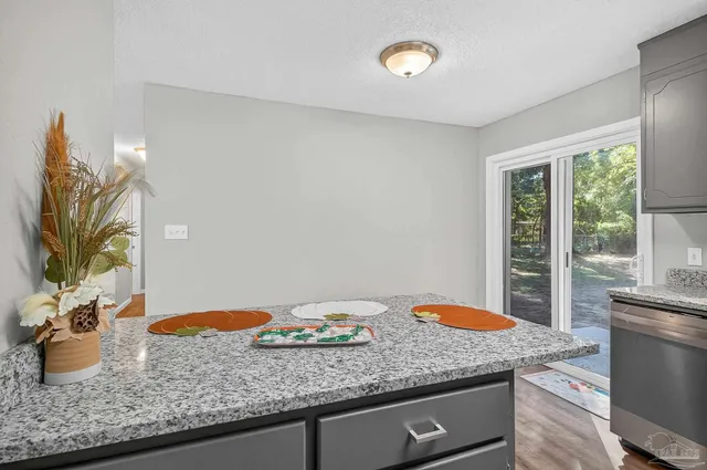 a kitchen with granite countertop a sink and a wooden floor