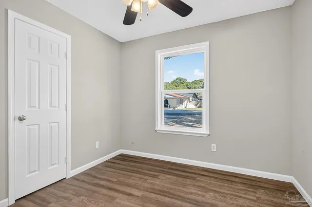 an empty room with window and wooden floor