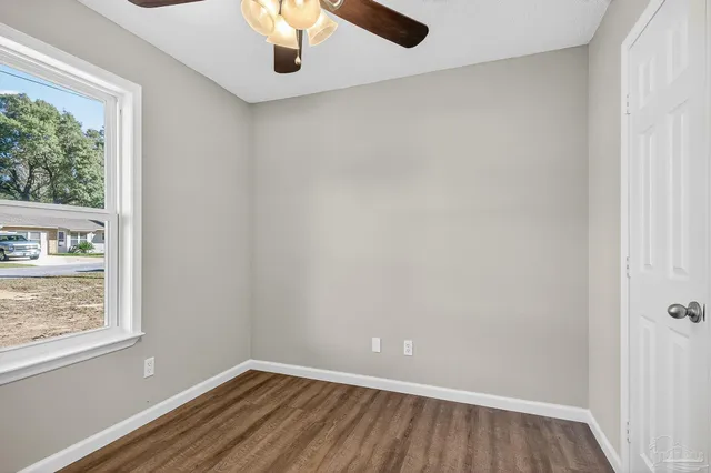 an empty room with a window and wooden floor