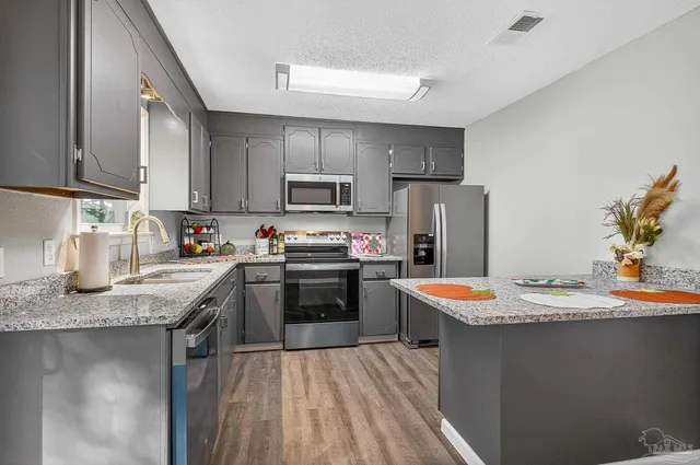 a kitchen with stainless steel appliances granite countertop a sink stove and refrigerator
