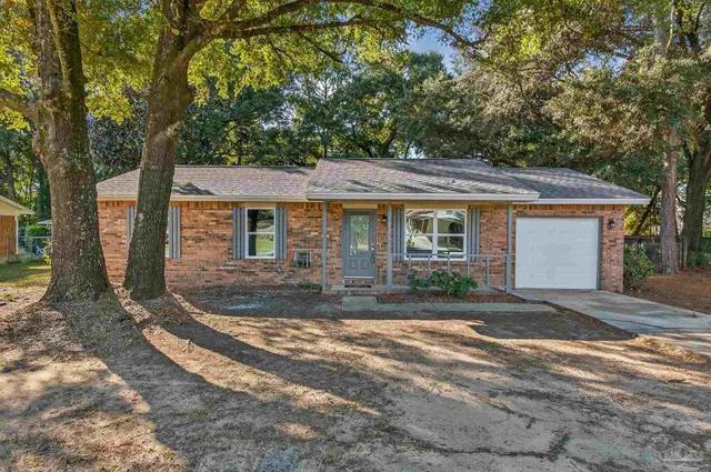 a view of a yard in front of a house with large tree