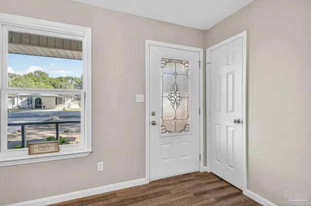 an empty room with wooden floor and a window
