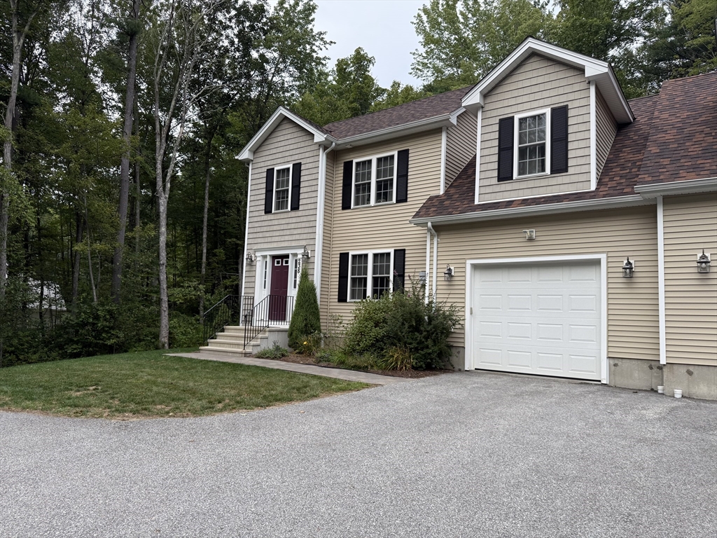 238 Barre Paxton Road, Unit 238 Rutland, MA 01543 - Photo 2 of 25 a front view of a house with a yard and garage