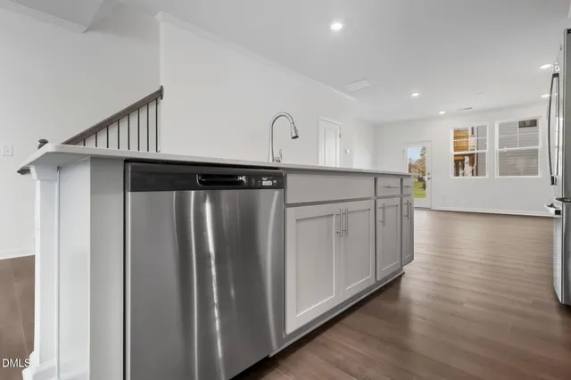 a kitchen with stainless steel appliances granite countertop a refrigerator and a stove top oven