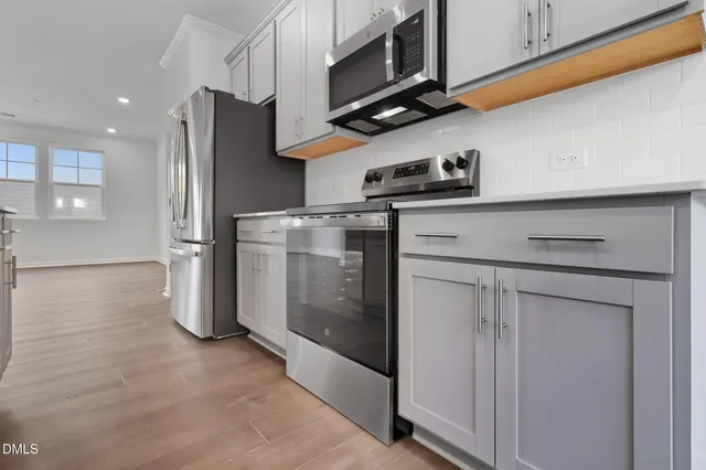 a kitchen with stainless steel appliances granite countertop a refrigerator a stove and a microwave