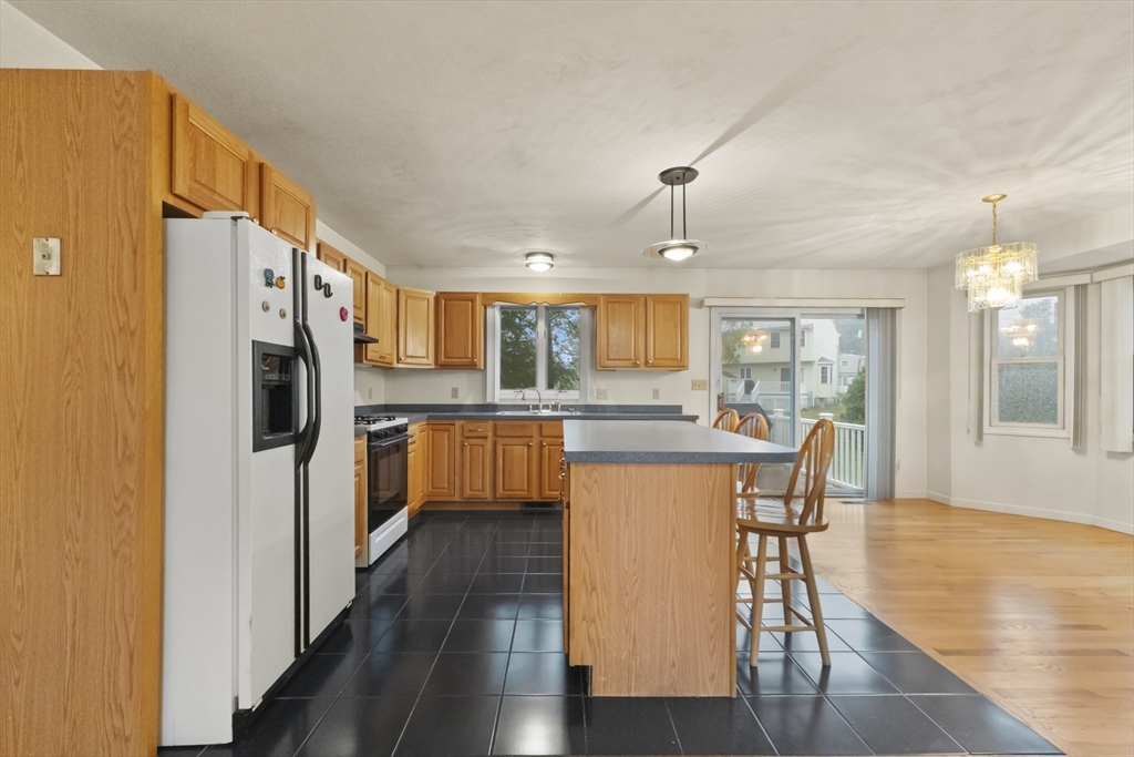 72 Ida Lane Fall River, MA 02720 - Photo 4 of 28 a kitchen with stainless steel appliances granite countertop a refrigerator a stove top oven a sink dishwasher and white cabinets with wooden floor