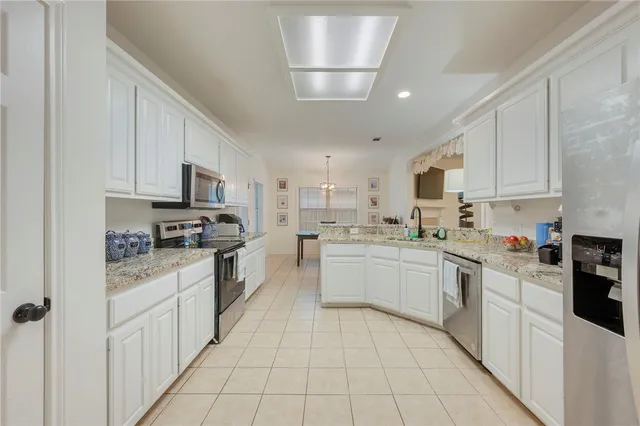 a kitchen with stainless steel appliances granite countertop a refrigerator sink and stove