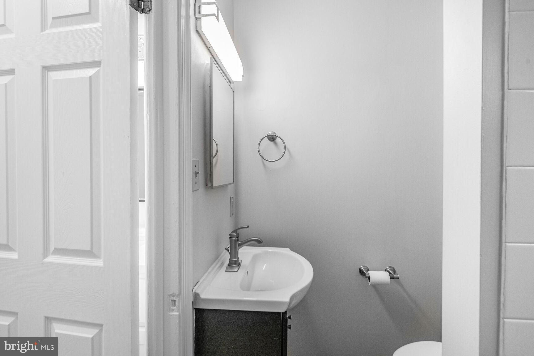 38 Pleasant Street Annapolis, MD 21401 - Photo 19 of 22 a bathroom with a sink mirror and toilet