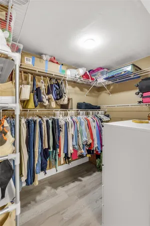 a view of walk in closet with clothes and shoes
