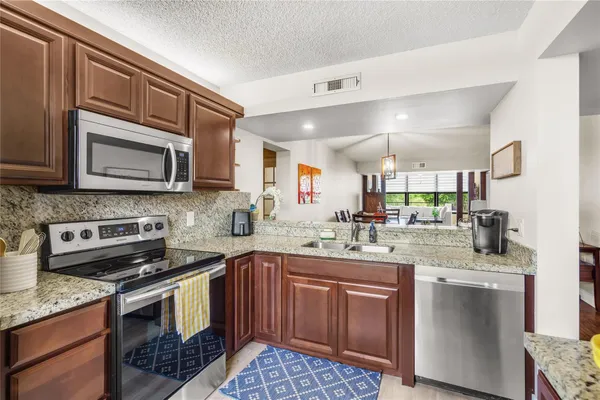 a kitchen with a sink stove and microwave