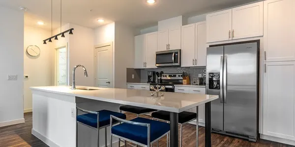 a kitchen with kitchen island a sink stove and refrigerator