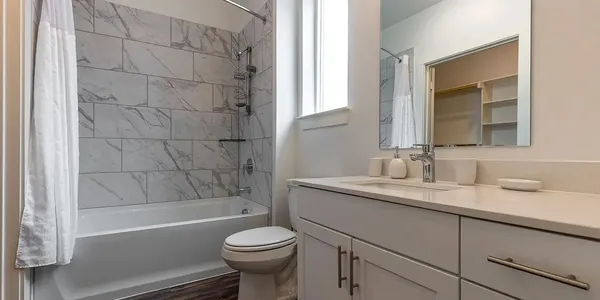 a bathroom with a sink a toilet and shower