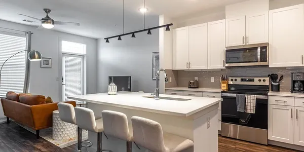 a kitchen with stainless steel appliances granite countertop a stove a sink island and a refrigerator