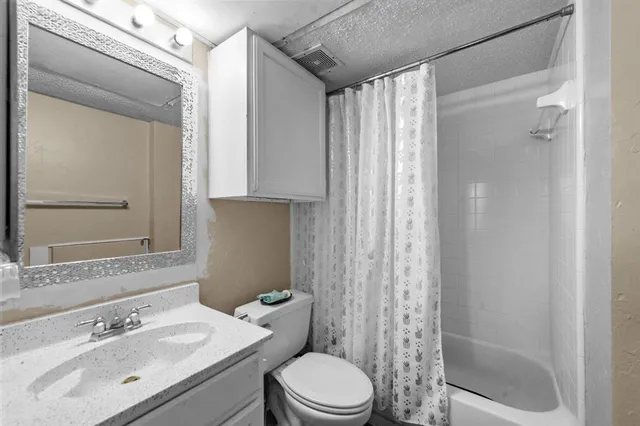 a bathroom with a sink mirror vanity and toilet