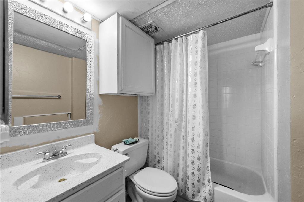 9815 Walnut Street, Unit 204 Dallas, TX 75243 - Photo 12 of 29 a bathroom with a sink mirror vanity and toilet