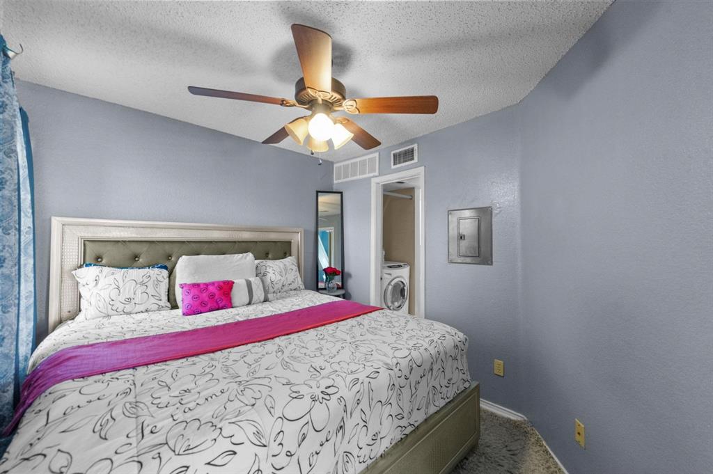 9815 Walnut Street, Unit 204 Dallas, TX 75243 - Photo 9 of 29 a bedroom with a large bed and a chandelier