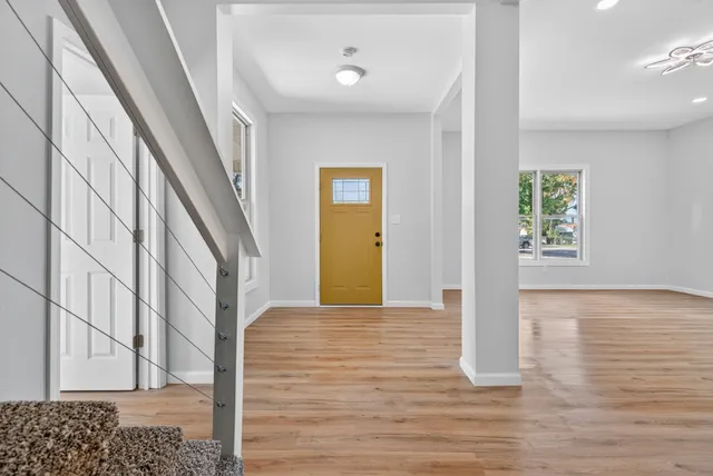a view of a hallway with wooden floor and staircase