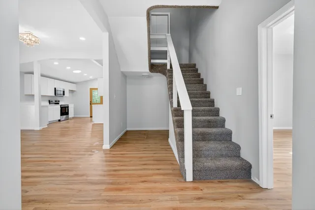 a view of empty room with wooden floor and stairs