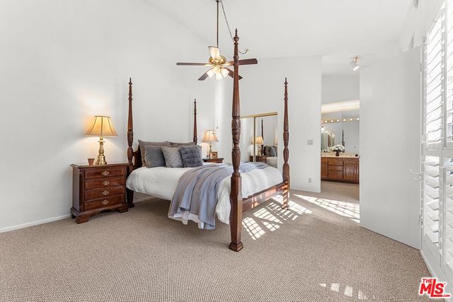 a spacious bedroom with a bed and a chandelier