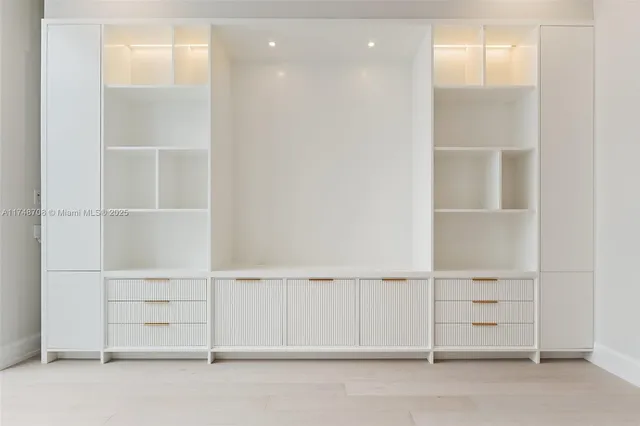 a view of an empty room with windows and balcony