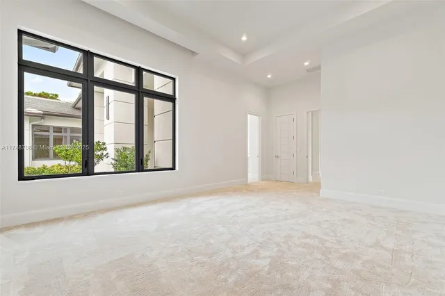 a view of empty room with ceiling fan and window
