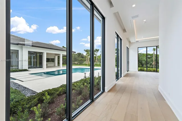 a view of a white house with a yard and potted plants