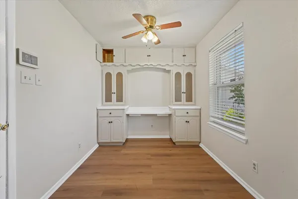 a view of a hallway with wooden floor and a chandelier