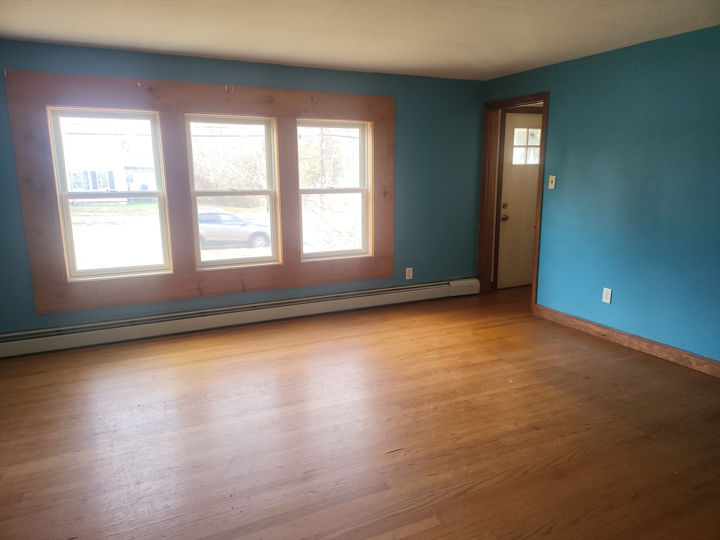 665 Parker Street Springfield, MA 01129 - Photo 12 of 25 an empty room with wooden floor and windows