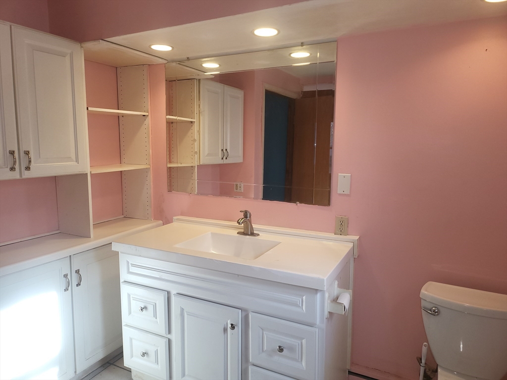 665 Parker Street Springfield, MA 01129 - Photo 6 of 25 a bathroom with a sink a toilet and a large mirror
