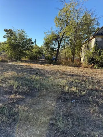 a view of dirt yard with a trees