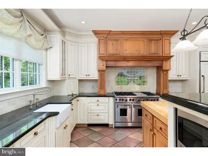 a kitchen with stainless steel appliances granite countertop a stove a sink dishwasher and cabinets with wooden floor