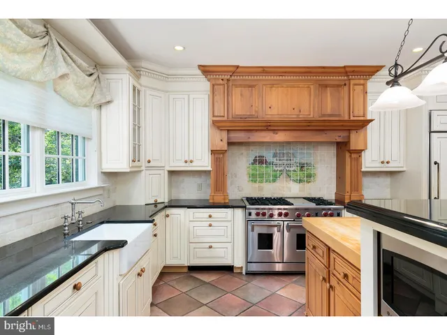 a kitchen with stainless steel appliances granite countertop a stove a sink dishwasher and cabinets with wooden floor