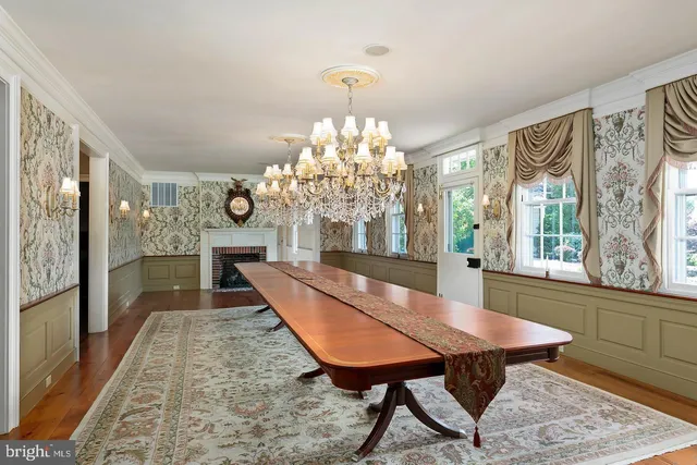 a dining room with furniture a chandelier and wooden floor
