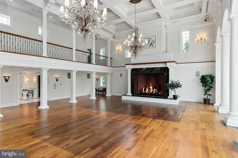 a view of an empty room with wooden floor fireplace and a window