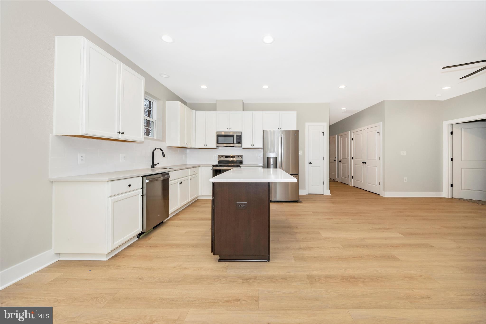7816 Fairplay Road Fairplay, MD 21733 - Photo 24 of 34 a large white kitchen with wooden floors stainless steel appliances