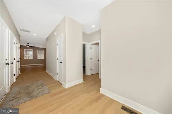 a view of a hallway with wooden floor and closet