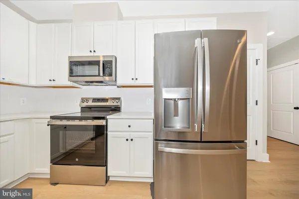 a kitchen with white cabinets and sink