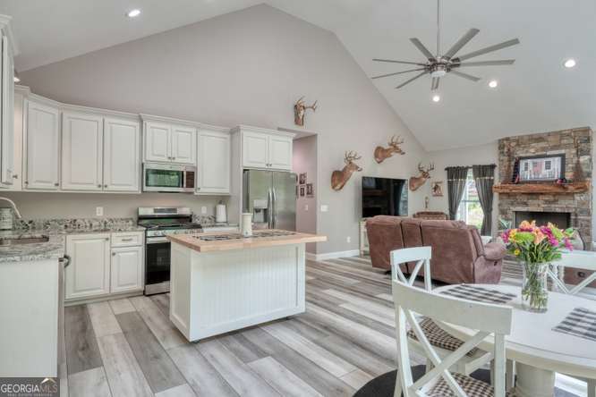 478 Flat Top Road, Unit 6 Young Harris, GA 30582 - Photo 4 of 70 a kitchen with stainless steel appliances kitchen island granite countertop a stove top oven a sink a dining table and chairs