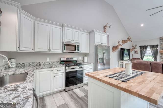 478 Flat Top Road, Unit 6 Young Harris, GA 30582 - Photo 46 of 70 a kitchen with kitchen island granite countertop a sink stainless steel appliances and white cabinets